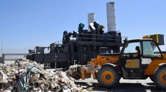 A bulldozer moves trash at a landfill