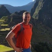 white man smiling in orange shirt