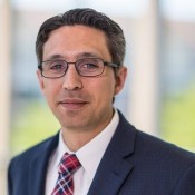 white man in red tie wearing glasses