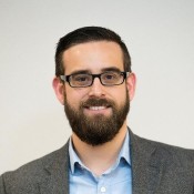 WHITE MAN IN BLUE SHIRT AND GREY BLAZER